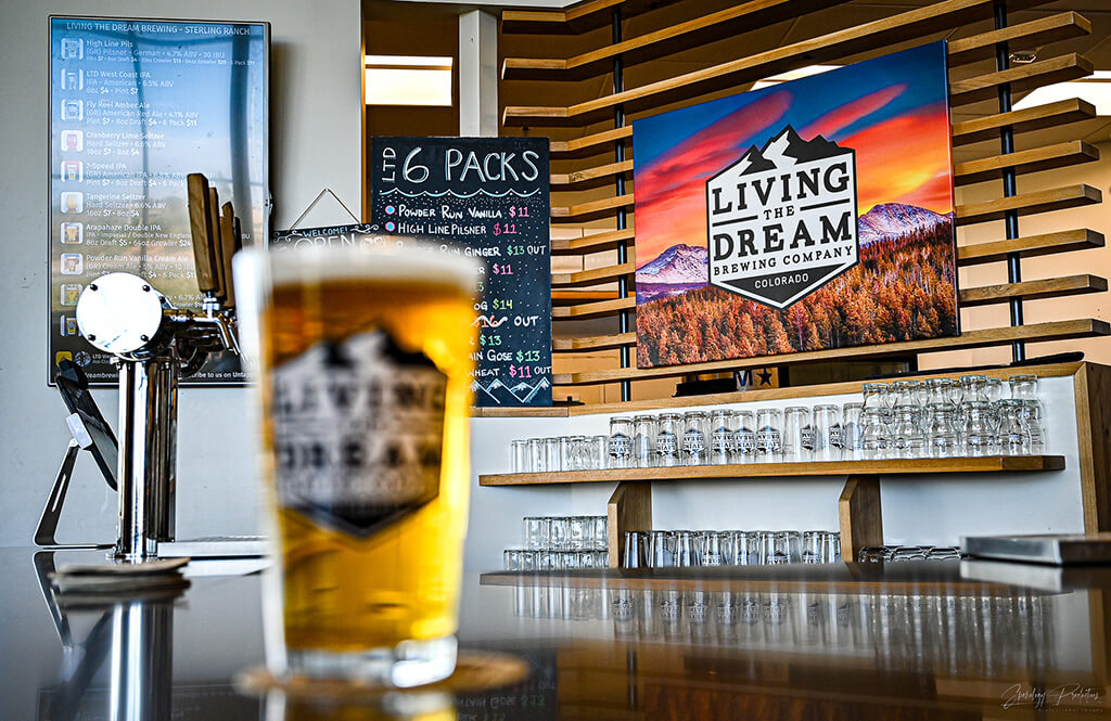 interior of Sterling Ranch location with digital tapboard and wall of beer glasses